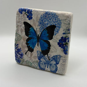Delicate blue butterfly artwork printed on square travertine stone coaster
