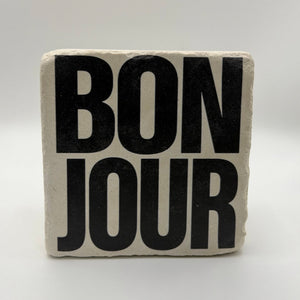 French phrase 'Bonjour' printed on square travertine stone coaster