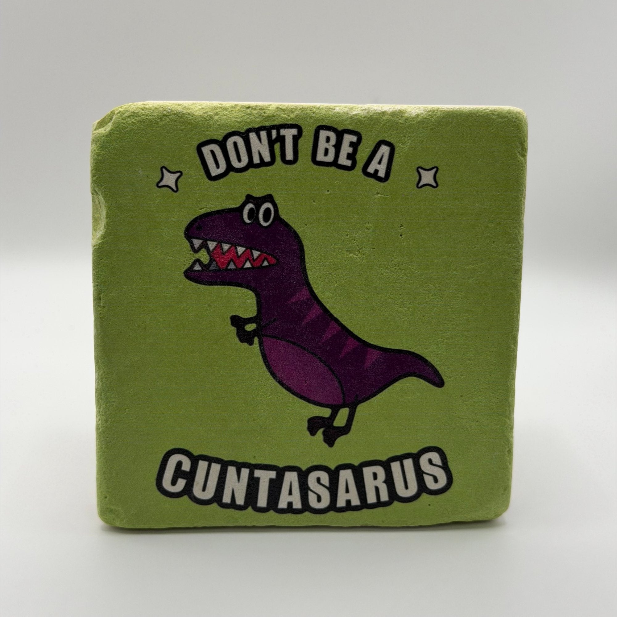 Funny slogan 'Don't Be a Cuntasaurus' printed on square travertine stone coaster