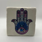 Hamsa hand symbol printed on square travertine stone coaster