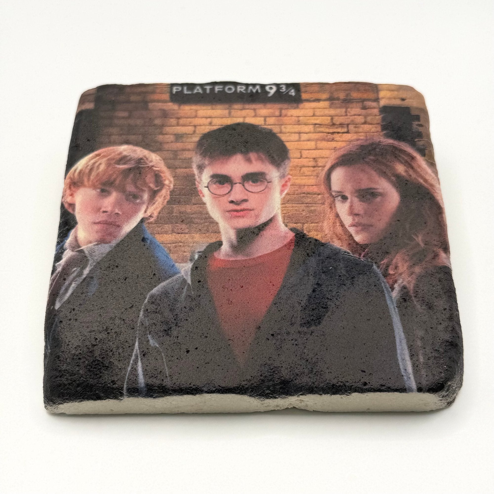 Harry Potter logo and numbers 9 and 3 quarters printed on square travertine stone coaster
