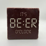 Funny quote 'It's beer o'clock' printed on square travertine stone coaster