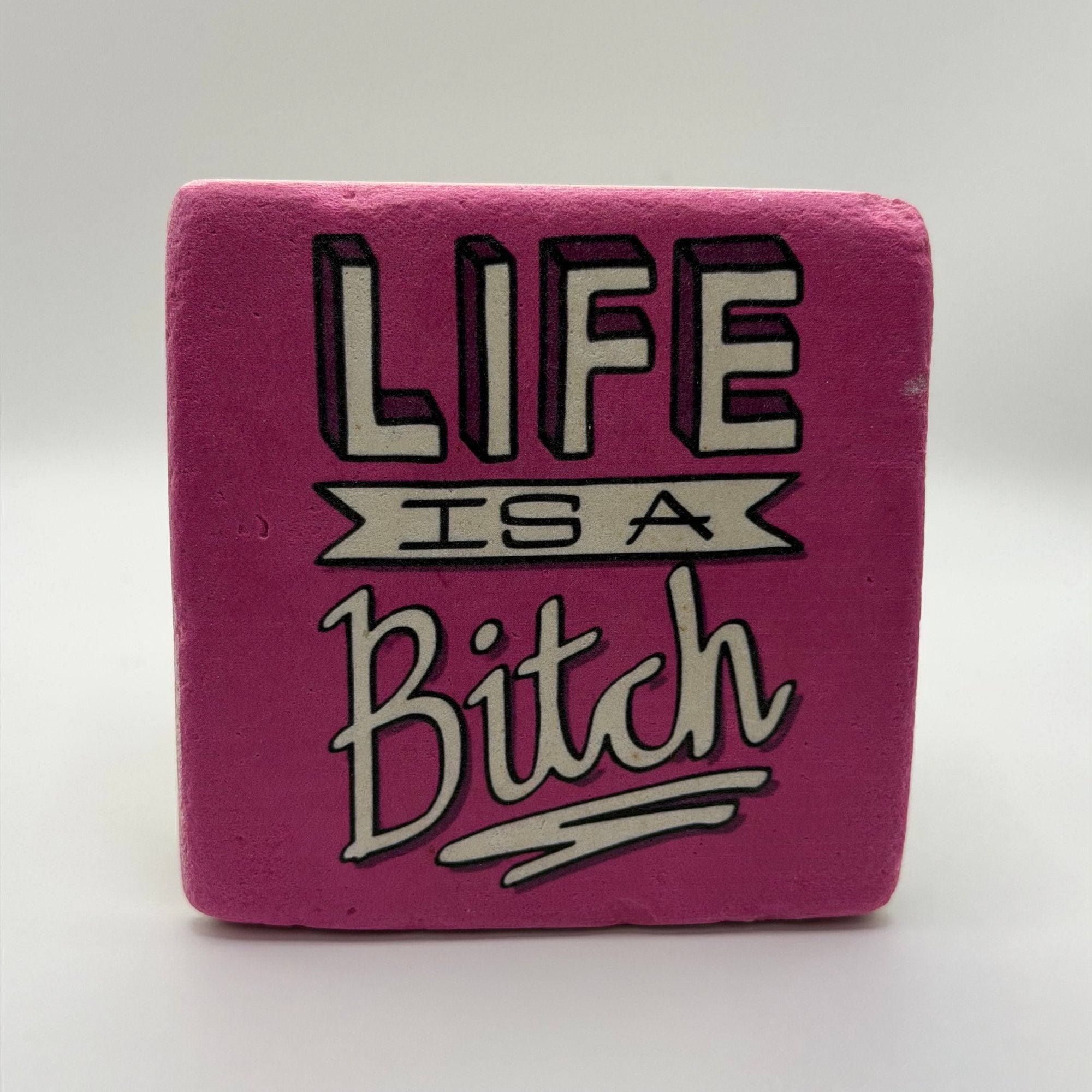 Sarcastic quote 'Life is a Bitch' printed on square travertine stone coaster