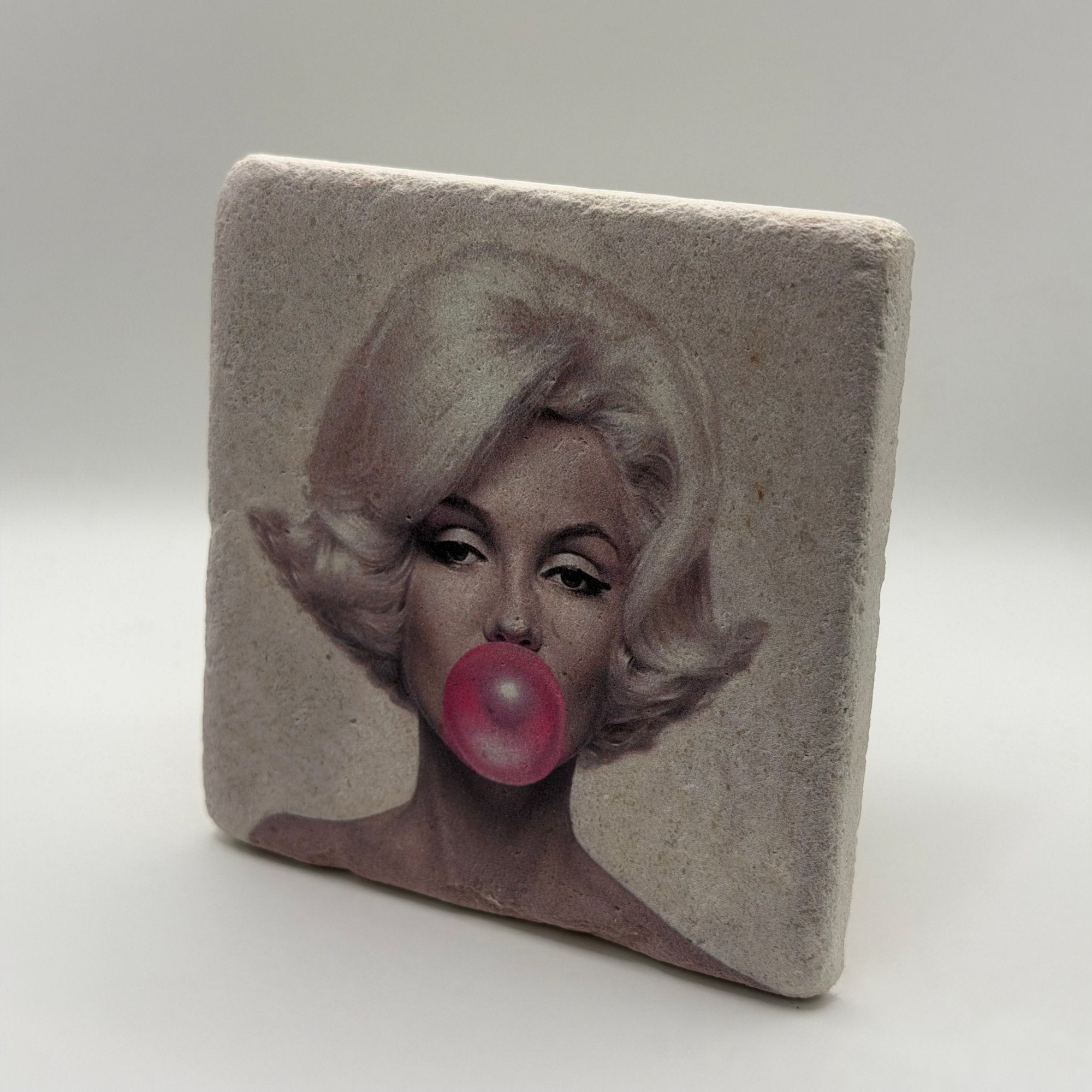 Marilyn Monroe's iconic pink bubble artwork printed on square natural travertine stone coaster