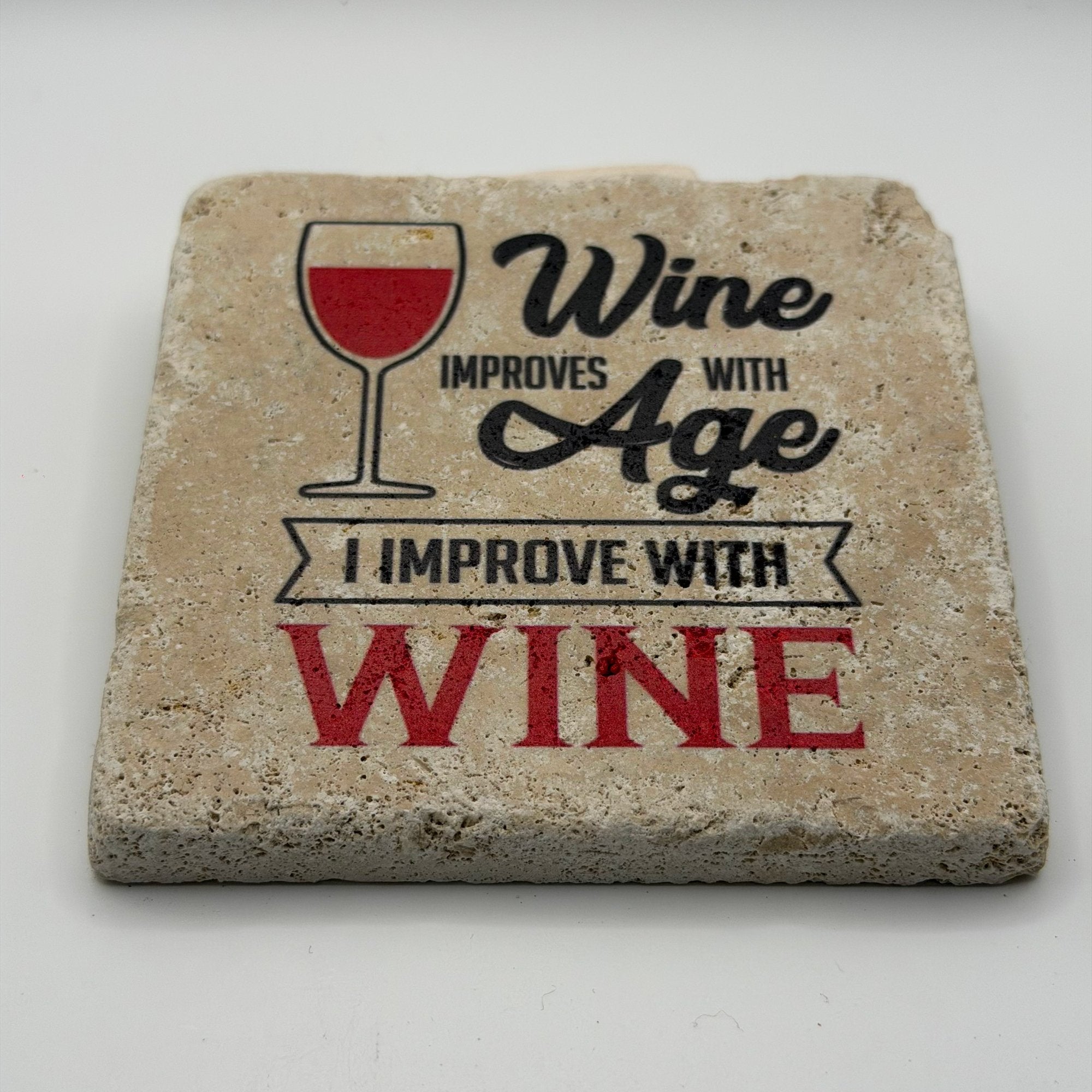 Wine improves with age quote printed on square natural travertine stone coaster